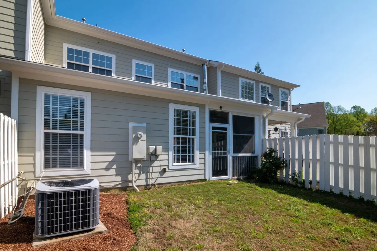 Gray lap siding home with freshly painted white trim and window frames under a clear sky in Lafayette LA